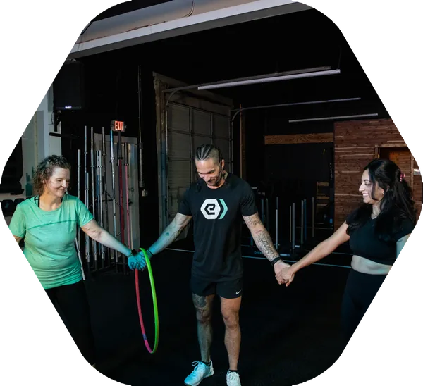 Clients and a coach working together on the training floor