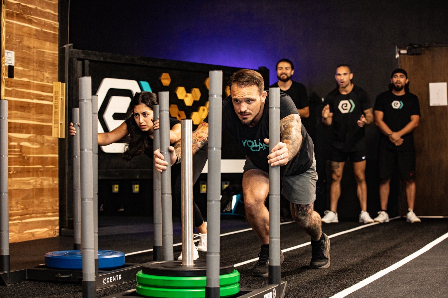 Clients pushing a weighted sled during a training session at e-motion wellness