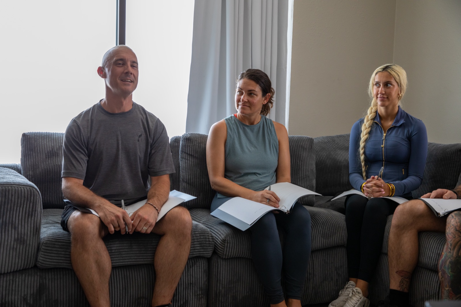 Group participants seated together on a sofa with workbooks during a session