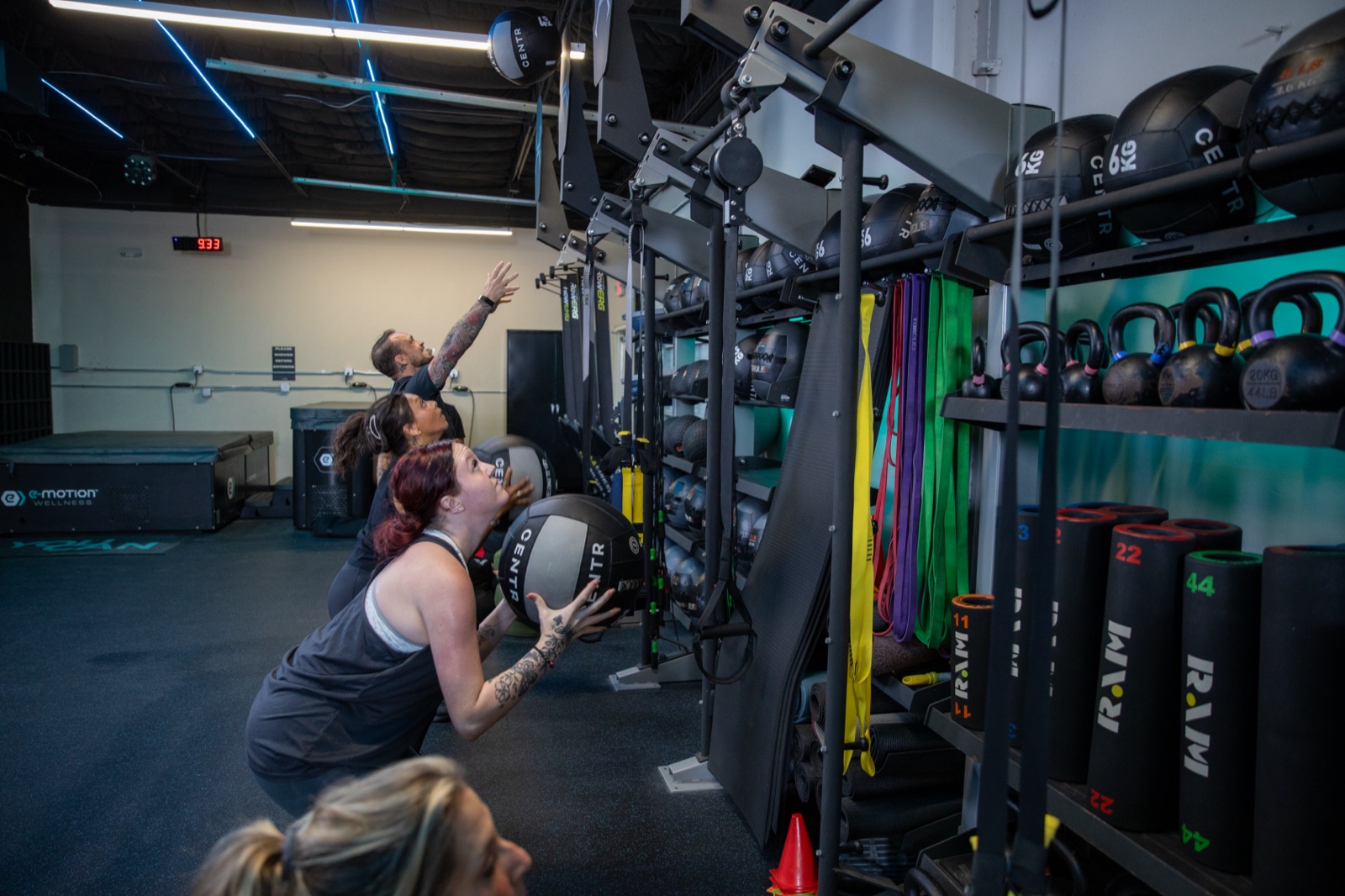 Clients doing medicine ball wall throws on the training floor